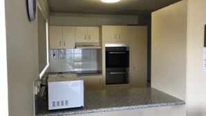 Una cocina equipada con horno empotrado, microondas y refrigerador.