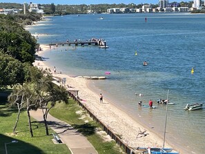 A beach with a wooden pier, clear water, and a city skyline in the background. - Riviere 718 Stunning Panoramic Golden Beach Views (Golden Beach)