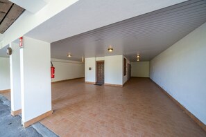Un grand espace intérieur doté d’un sol carrelé, d’un extincteur et d’une porte.
