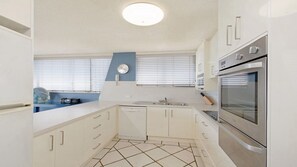 A kitchen with white cabinetry, a built-in oven, and a tiled floor.