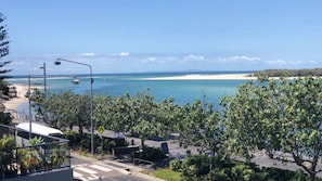 Une vue sur la côte, avec un passage piéton, une plage et un ciel dégagé.