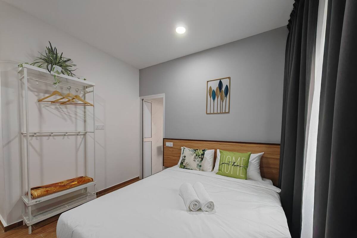Una habitación de hotel con cama, armario, espejo y puerta.