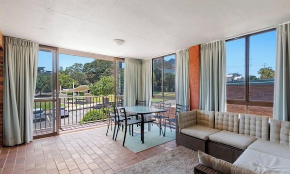A spacious room with a balcony, a dining table, and a sofa. - Highlander 4 Kings Beach 2Br With Pool (Kings Beach)
