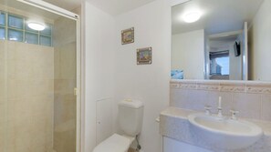 Un bagno con il water, lavandino e doccia.