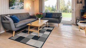 A modern living room with two grey sofas, a wooden coffee table, and a black and white rug. - 6 Person Holiday Home in Otterup (Otterup)