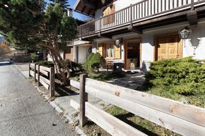 A traditional chalet with a wooden balcony, stone steps, and a wooden fence. - 5' Bus to the Ski Slopes, Panoramic Chalet (Pallenc)