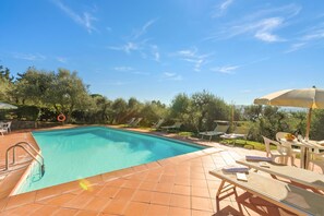 A swimming pool with a tiled deck, lounge chairs, and an umbrella. - Chianti Apt Olmo&Pini Shared Pool, Castelfiorentino, Italy (Castelfiorentino)