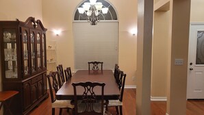 A dining room with a large wooden table and chairs, a china cabinet, and a chandelier. - Nice House in One of the Best Neighborhood in Tallahassee (Tallahassee)