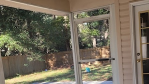 A covered patio area with a ceiling fan, large windows, and a view of a backyard. - Nice House in One of the Best Neighborhood in Tallahassee (Tallahassee)