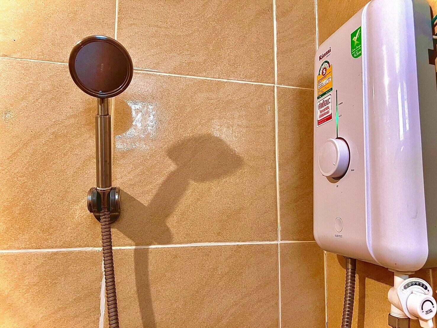 Een douche met bedieningspaneel en douchekop.