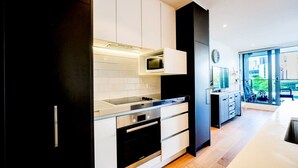 Une cuisine moderne avec des meubles blancs, un four à micro-ondes encastré et un four en acier inoxydable.