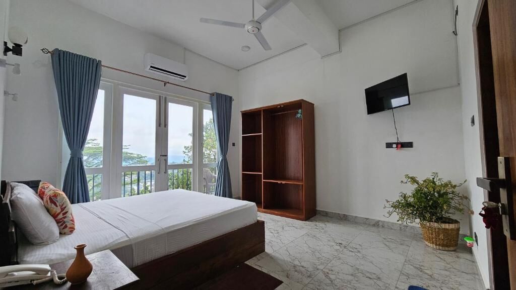 Un dormitorio con cama, armario, televisor y una planta en maceta.