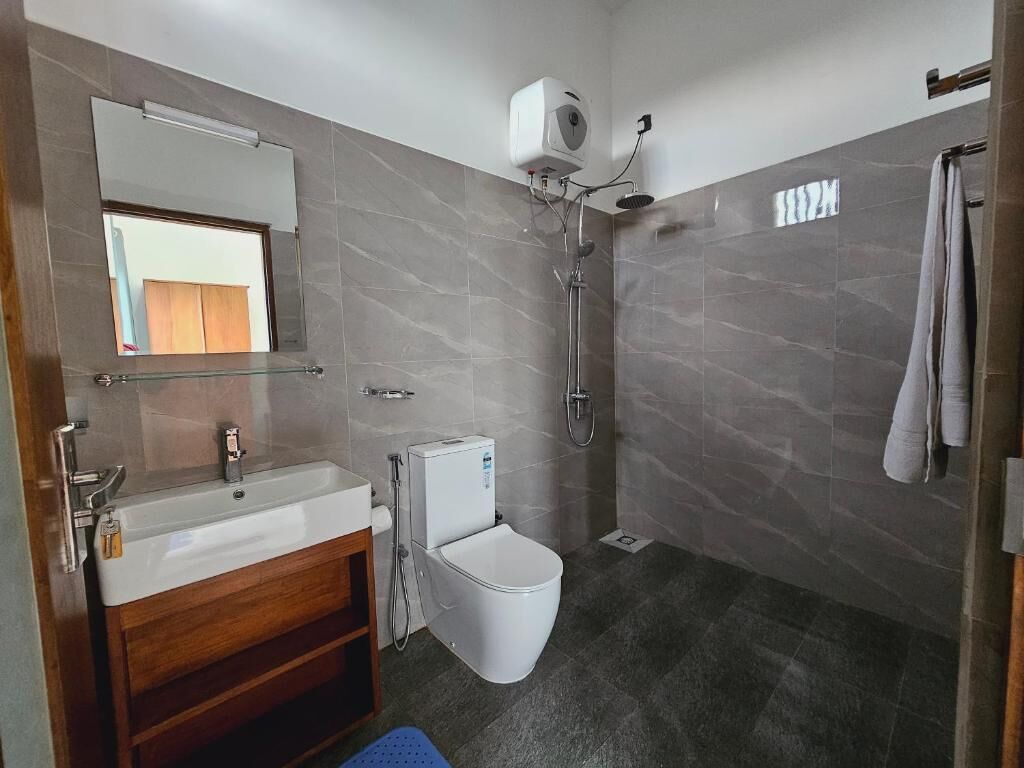 A modern bathroom with a sink, toilet, and shower.
