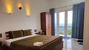 Una camera da letto con un letto grande, un armadio, un comodino e vista sull'esterno tramite una porta scorrevole.