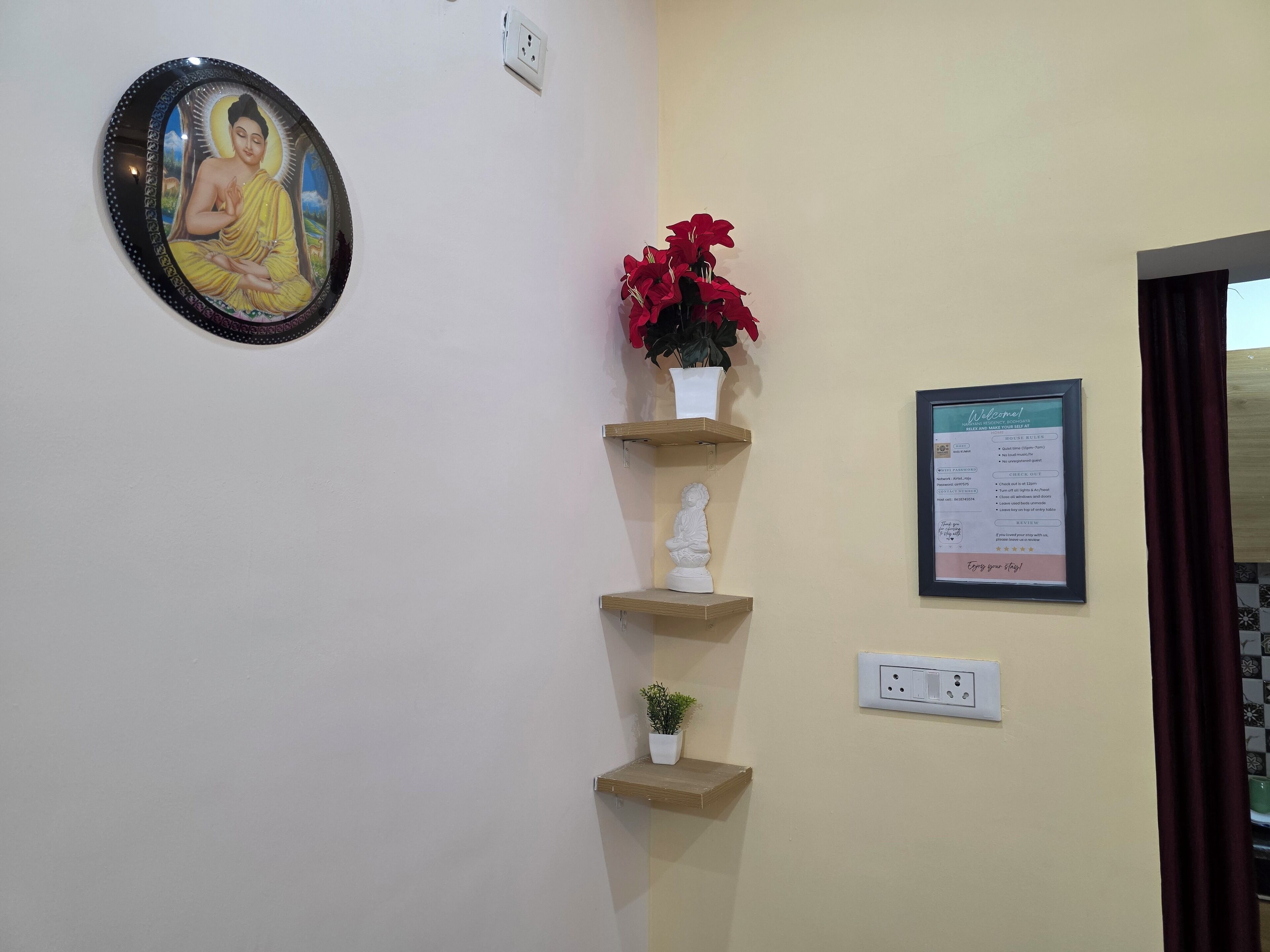 Ένας χώρος υποδοχής με μια φωτογραφία του Βούδα σε κορνίζα, μια επιγραφή καλωσορίσματος και ένα μικρό άγαλμα του Βούδα σε ένα ράφι.