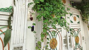 A building facade with decorative elements, a 'Please Ring Bell' sign, and a door with intricate designs. - Narayans Residency (Gaya)