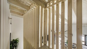 Un intérieur moderne avec des lambris en bois, une plante en pot et une vue sur l’extérieur.