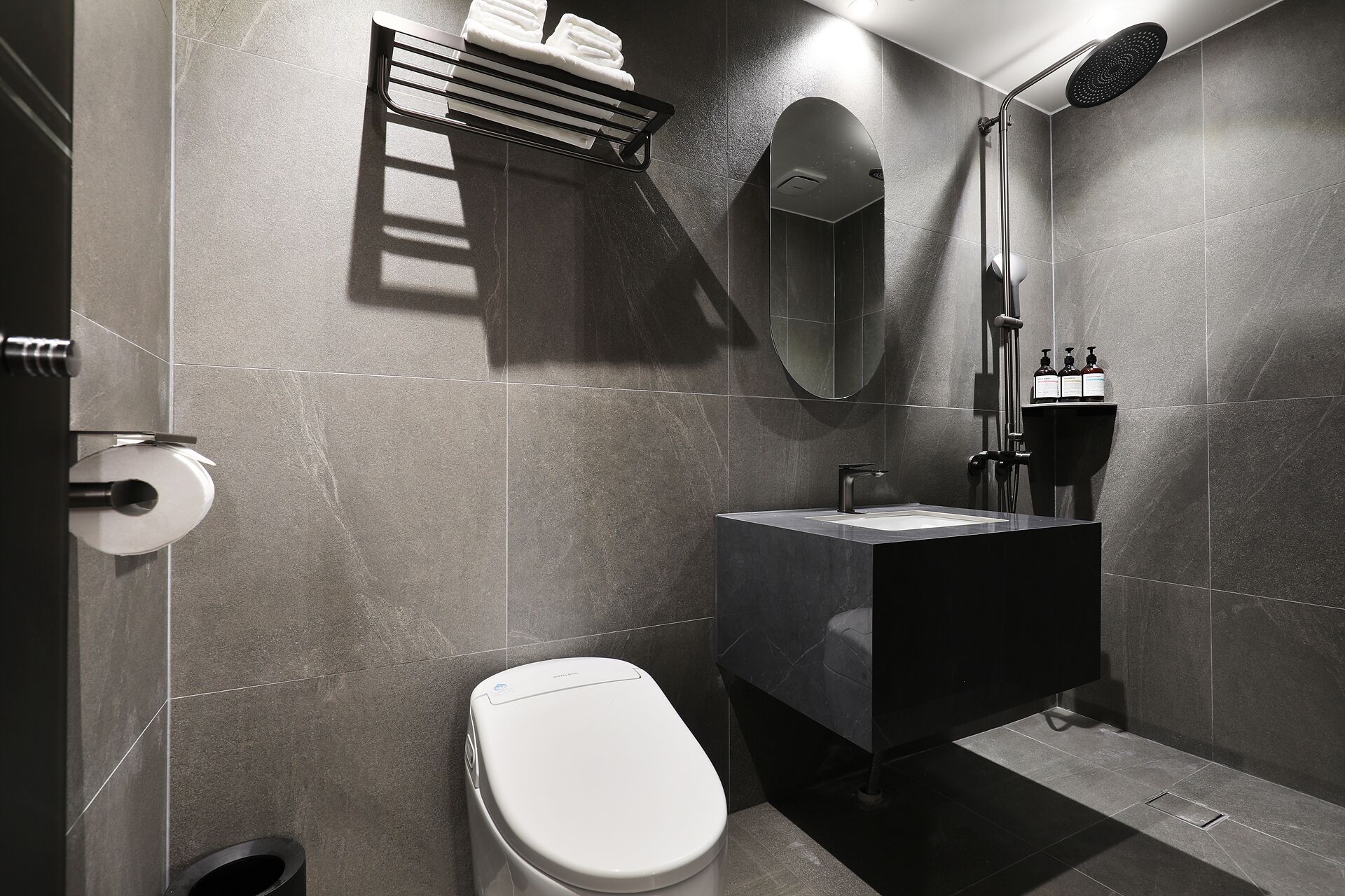 Un baño moderno con inodoro, lavamanos y ducha.