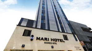 A tall building with a sign reading "MARI HOTEL BUSINESS HOTEL" and a parking sign below. - marihotel (Seosan)