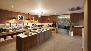 A modern kitchen with a central island, wooden paneling, and a stone accent wall. - marihotel (Seosan)