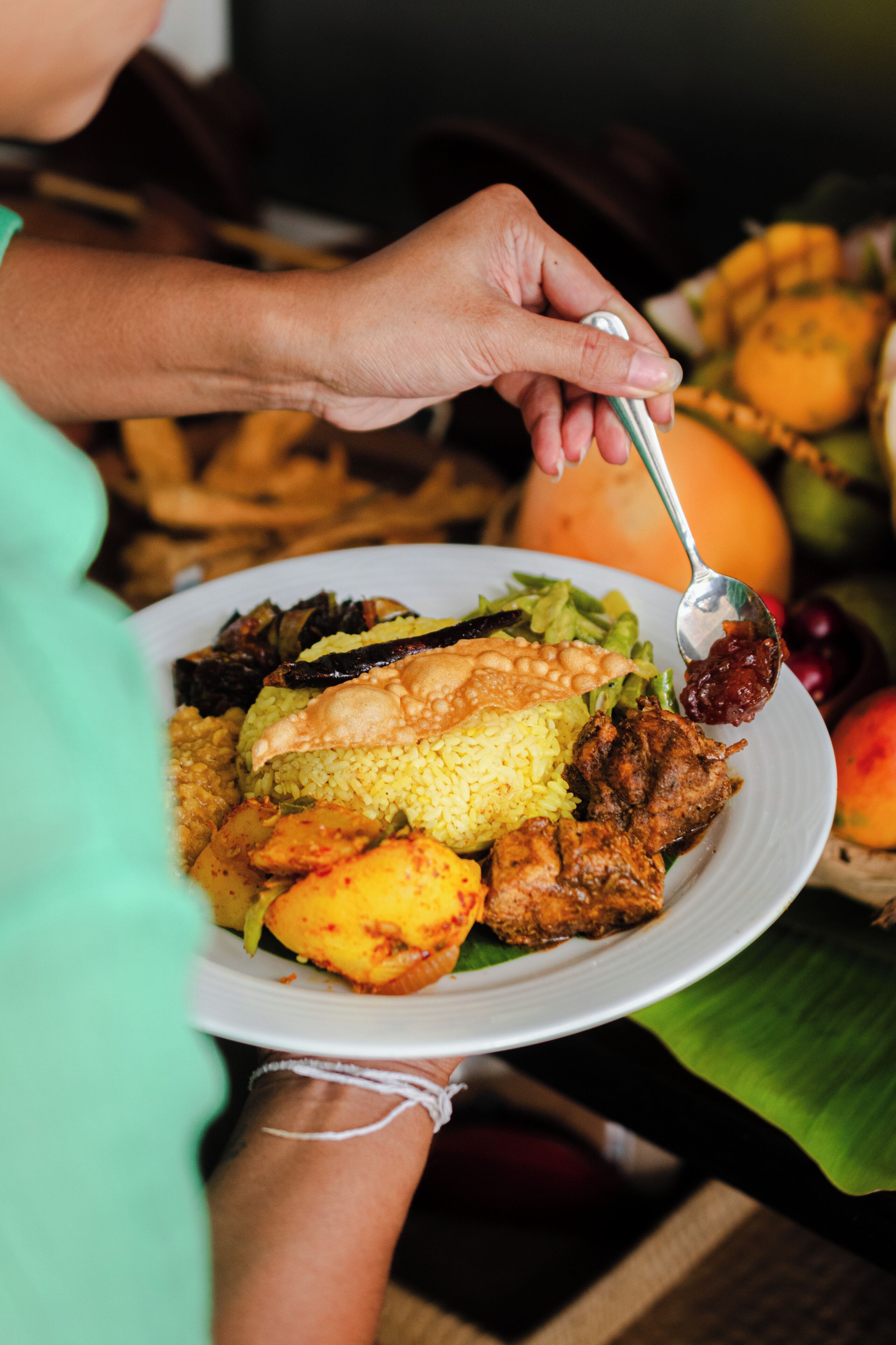 Una persona sosteniendo un plato con diversos alimentos, como arroz, carne y verduras.