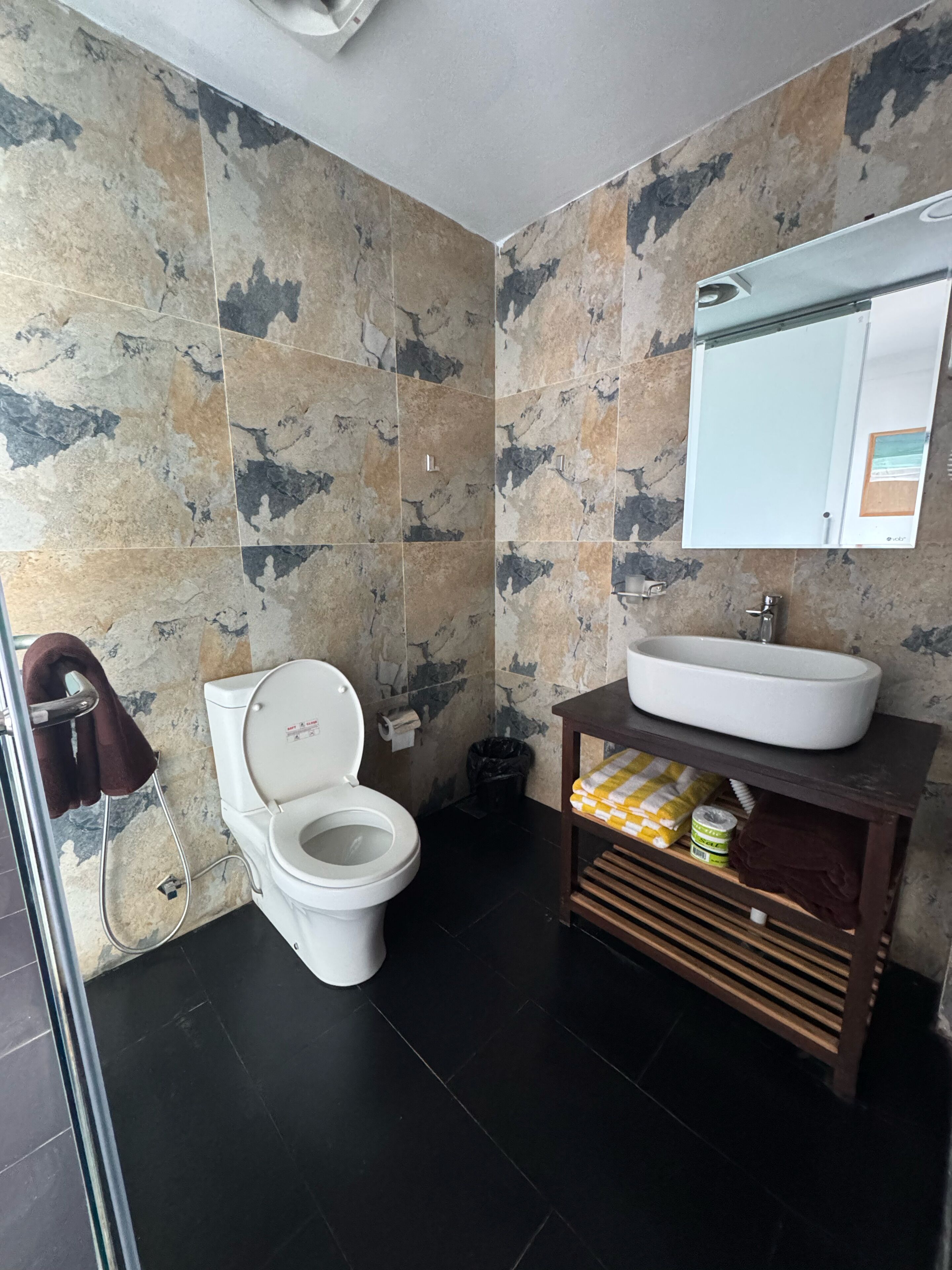 A modern bathroom with a toilet, sink, and shower.