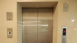 Un ascensor moderno con acabados metálicos, pantalla digital y panel de control.