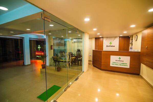 A reception area with a sign indicating it is a carbon neutral property. - EcoValue Kochi - 200 meters from Kerala High Court (Kanayannur)