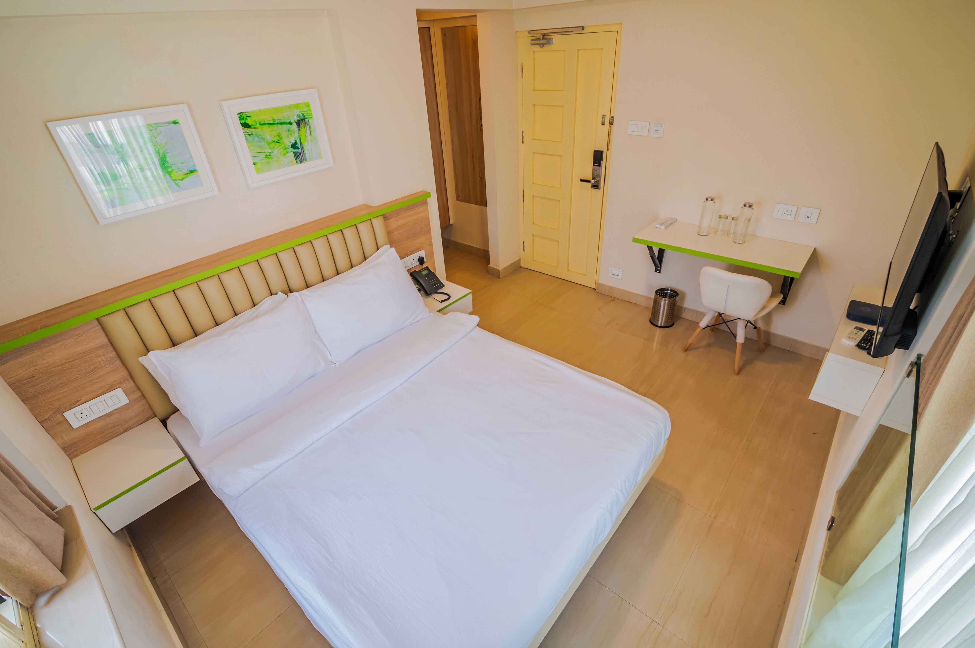 Una camera d'albergo con un letto, comodino, sedia, scrivania e televisore.