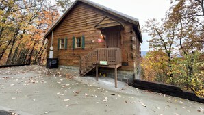 Een houten hut met een veranda, een bord dat uitzicht op de bergen aangeeft, en het nummer 3076 aan de zijkant.