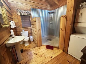 A compact wooden cabin bathroom with a sink, toilet, and shower. - Wow! Honeymoon Cabin with Fantastic Views. Very Private and 5 minutes to Parkway (Sevierville)