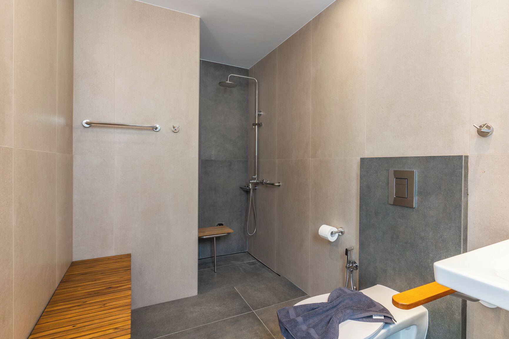 A modern bathroom with a shower, toilet, and sink.