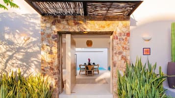A stone archway leading to a dining area with a table and chairs.