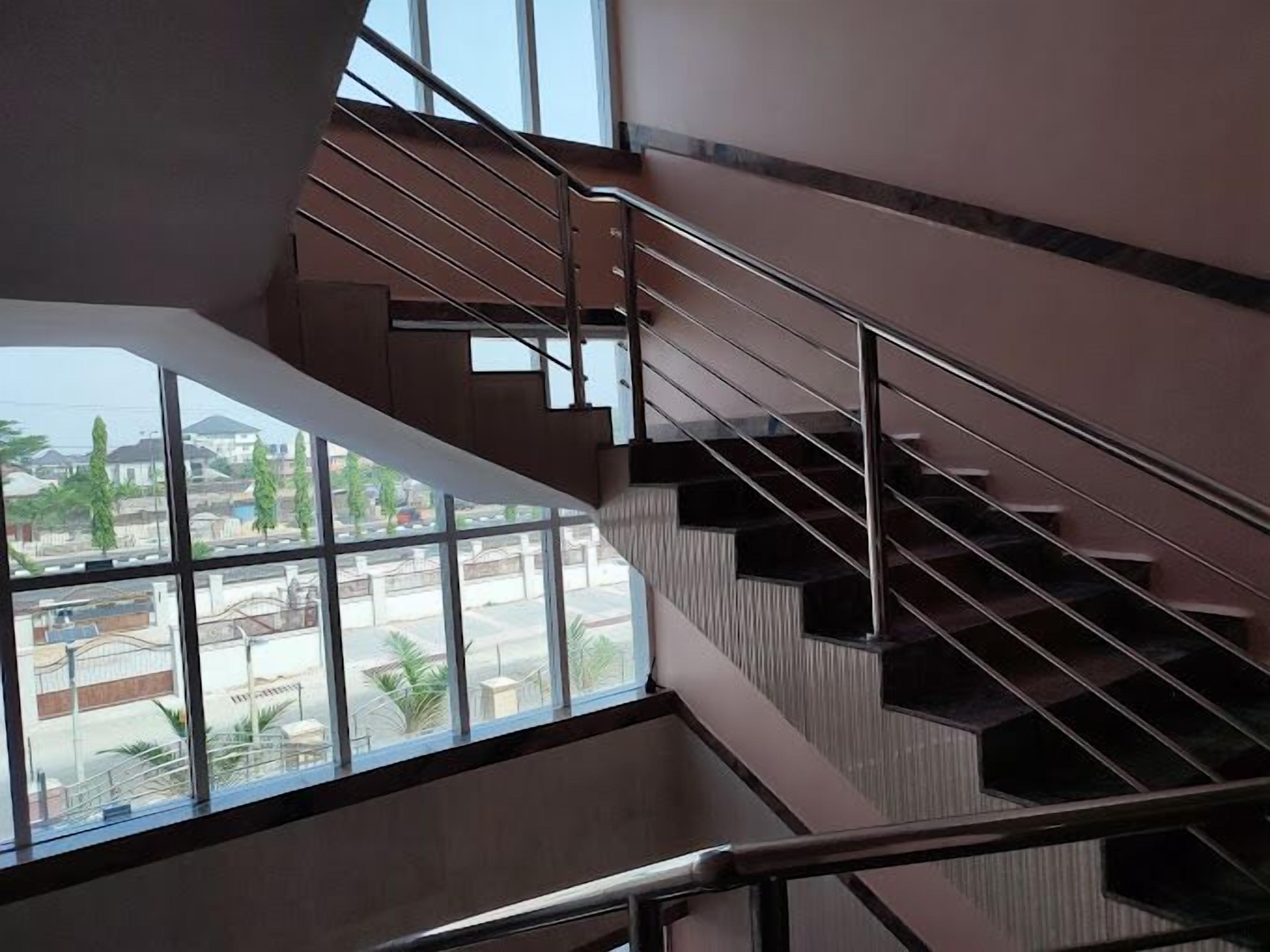 A multi-level interior with a staircase and large windows offering a view of the outside.