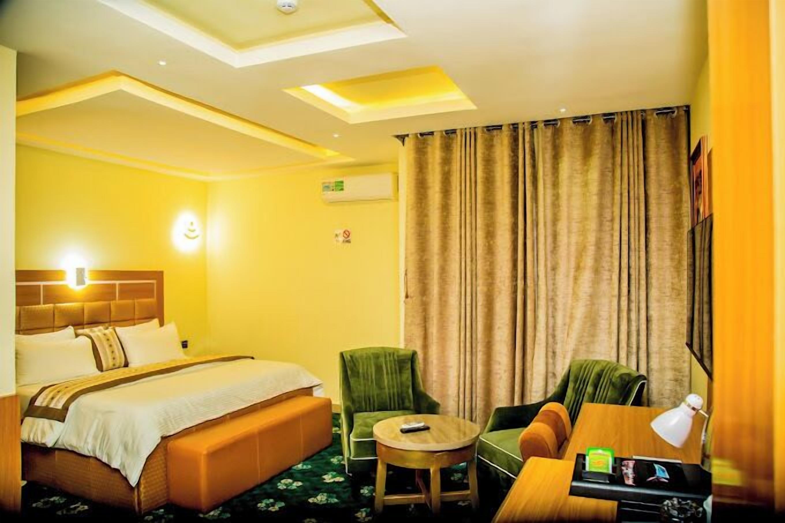 Una habitación de hotel con una cama, un sofá, una mesita y una silla.