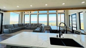 A spacious kitchen with a large island, a built-in oven, and a dining area with a view of the mountains. - Bear Lake getaway for the whole family! Sleeps 32! Beach access included!! (Garden City)