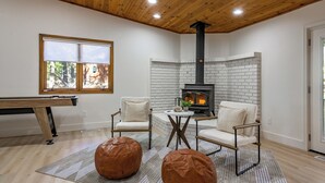 A cozy room with a fireplace, two chairs, a small table, and a pool table. - Summit Sanctuary: Urban Elegance mins from Downtown (Flagstaff)