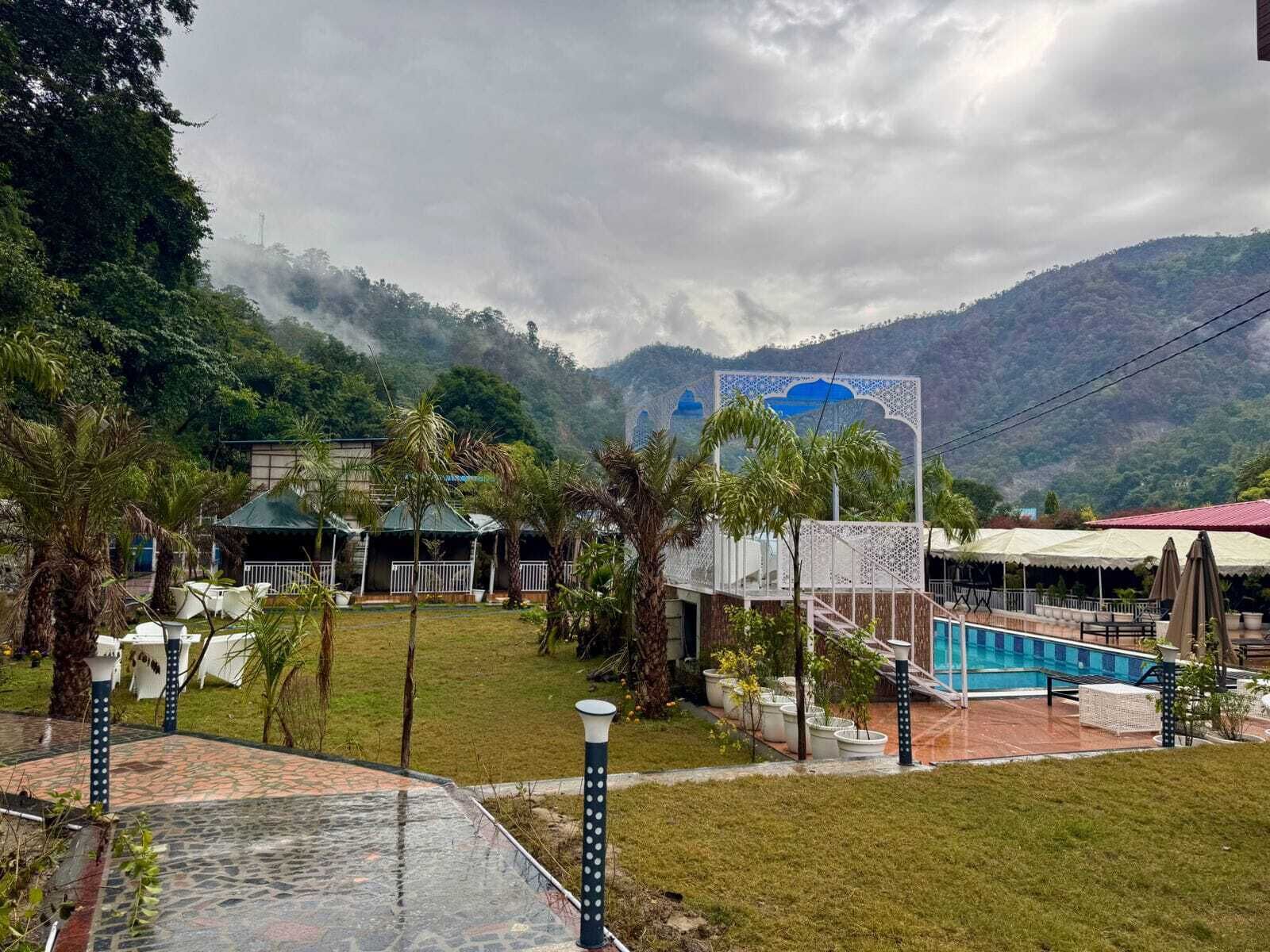 A resort with a pool, outdoor seating, and a view of mountains.
