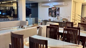 Un comedor moderno con una mesa de vidrio, sillas de madera y un ventilador de techo.