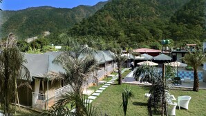 Un resort con piscina, zona de estar al aire libre y vistas a las montañas circundantes.