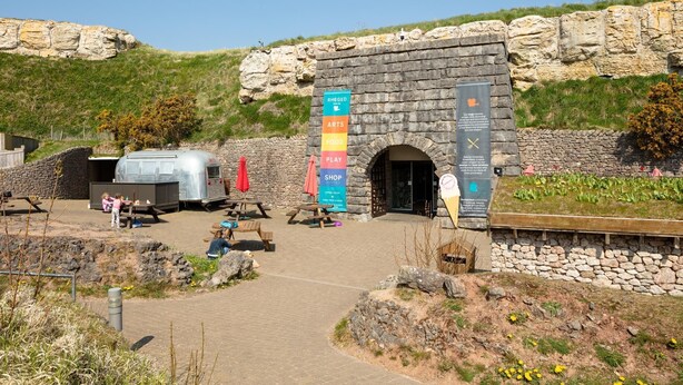 A stone building with a sign listing amenities like arts, food, and play. - Egerton House Penrith -  a cottage that sleeps 8 guests in 4 bedrooms (Penrith)