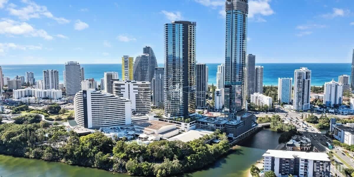 Un paysage urbain côtier avec de hauts immeubles, une rivière et une vue dégagée sur l’océan.