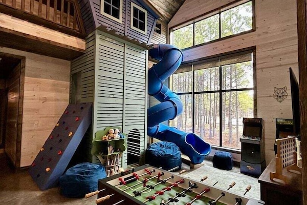 Game area which includes rock climbing wall, treehouse slide, arcade games & foosball table
