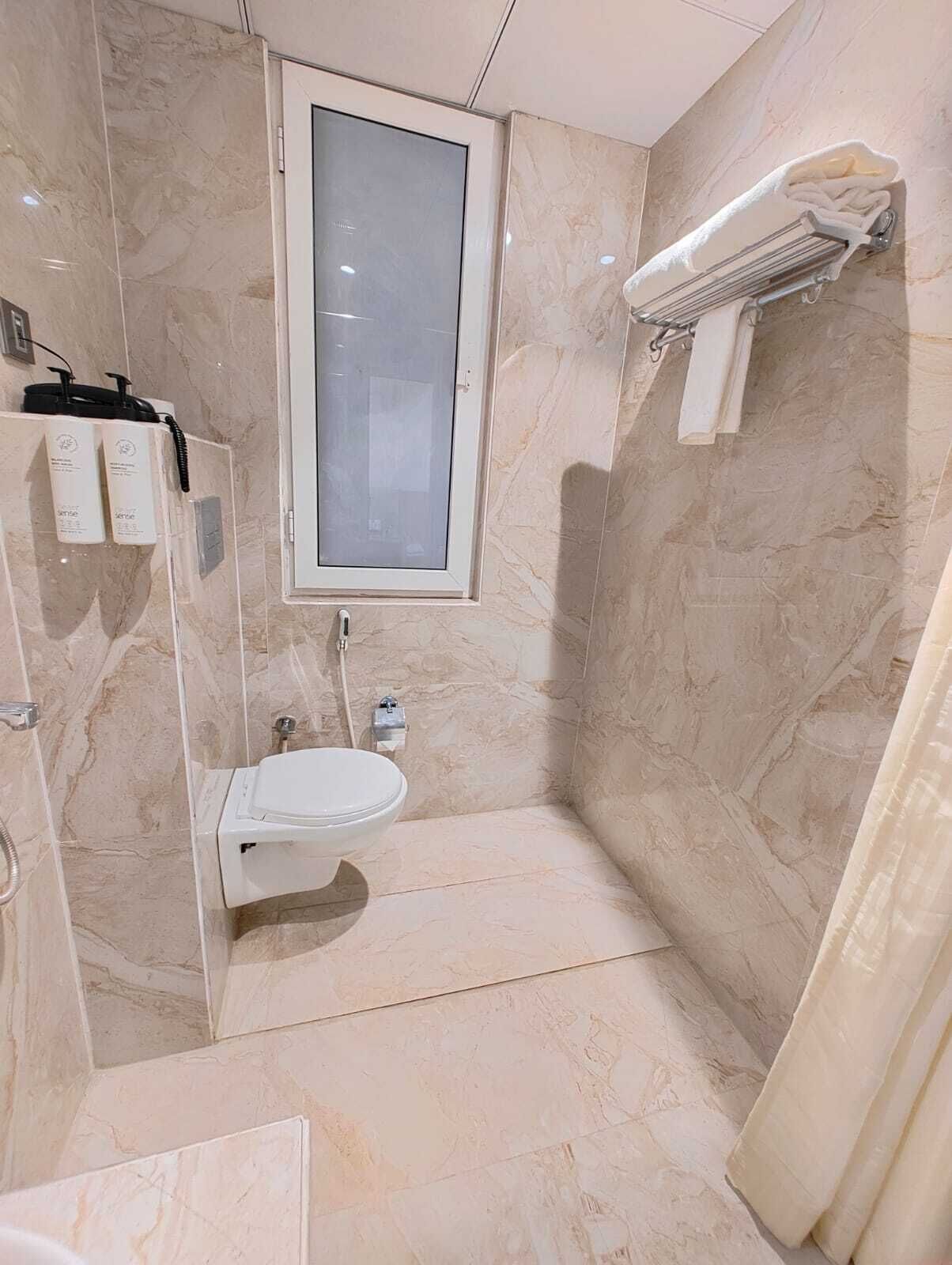 A bathroom with a toilet, a sink, and a shower area.