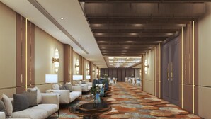 A hotel corridor with seating areas, chandeliers, and a patterned carpet. - The Eco Satva Kota - Vegetarian with all Options (Kota)