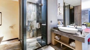Un baño moderno con cabina de ducha de vidrio, un espejo grande y un lavabo con encimera de mármol.
