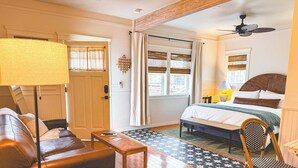 Un dormitorio acogedor con cama, una silla, una mesa y una lámpara.