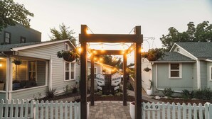 A gated entrance with a wooden archway, a white picket fence, and a house number 649. - Swank Suites | Step Free King - Pet Friendly (Ashland)