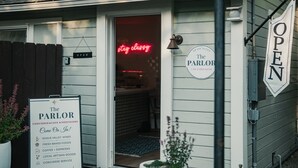 Een gebouw met een bord waarop 'The Parlor' en 'OPEN' staat, wat duidt op een bedrijf.
