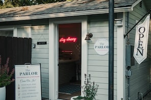 A building with a sign indicating 'The Parlor' and 'OPEN' on the door, suggesting a business establishment. - Swank Boutique Suites | King Suite | DT Ashland (Ashland)